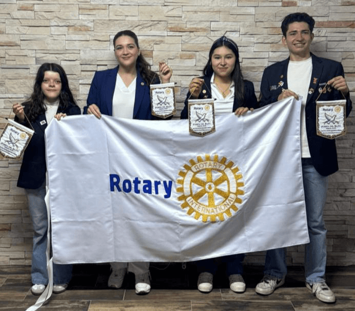 Jóvenes de intercambio con bandera Rotary